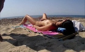 😜 I pull out my dick and begin to masturbate when I see this sexy brunette milf fingering her mature pussy while she is lying naked on the beach sand.